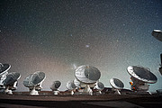 The Atacama Large Millimeter/submillimeter Array (ALMA) by night, under the Magellanic Clouds