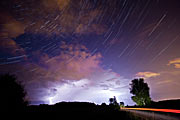 The constellation of Cassiopeia over a thunderstorm