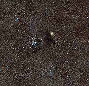 Den starkt lysande stjärnhopen NGC 6520 och det underligt formade molnet Barnard 86