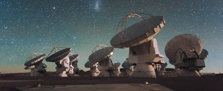 The Atacama Large Millimeter/submillimeter Array (ALMA) by night, under the Magellanic Clouds