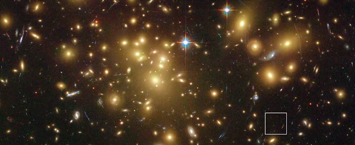 Vzdálená na prach bohatá galaxie A1689-zD1 ležící za kupou galaxií Abell 1689 (popiska)