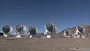 Pan over ALMA array of antennas on Chajnantor as they move in unison