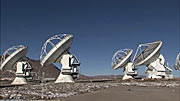 Pan over ALMA array of antennas on Chajnantor as they move in unison